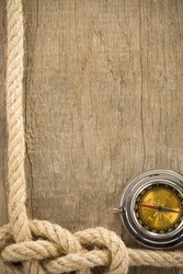 ship ropes and compass on wooden background texture