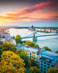 Scenic top view of the Hungarian Parliament and Chain Bridge on the Danube river at sunset. Location place Budapest, Hungary, Europe. Photo of popular tourist attraction of the world. Beauty of earth.