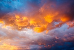 An epic sunset with colorful clouds lit by the sun. Photo of textured sky. Scenic image of dramatic light in summer weather. Breathtaking natural wallpaper background. Discover the beauty of earth.