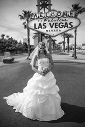 Beautiful bride poses at the las vegas sign