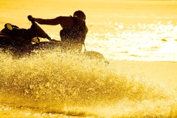 strong man drive on the jet ski above the water at sunset .silhouette. spray.
