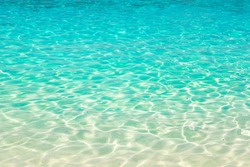Clear water reflections on shallow sandy beach bottom, Thailand in a summer day