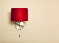 Red lamp on beige wall background