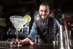 This is a photograph of barman serving cocktail margarita.