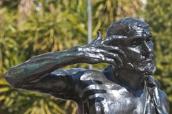 Head, arms and shoulders of the bronze statue Jaques de Wissant, 1888 by Rodin displayed in Murcia, Spain, in the open air with blue reflections from the blue sky  The Thinker.