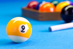 Billiard pool game nine ball with cue and nineball balls set up on billiard table with blue cloth