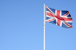 British Union Jack flag on deep blue sky with space for text