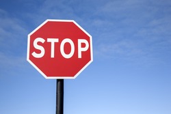 Red Stop Traffic Sign on Blue Sky Background