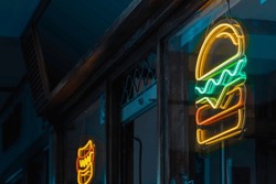 Fast food establishment by night with a hamburger neon sign