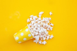 pop corn in a vase in yellow background.top view.Minimalist