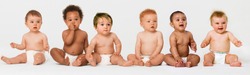 Row of six multi ethnic Babies smiling in studio