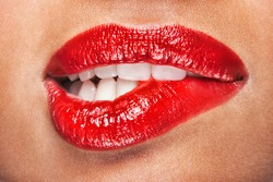 Closeup of sensuous woman biting red lips