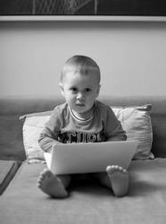 Boy sitting on sofa and using laptop