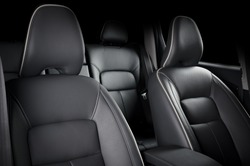 Luxury car inside. Interior of prestige modern car. Comfortable leather seats. Black perforated leather cockpit.