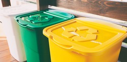 Three colorful trash cans for sorting garbage. For plastic, glass and paper