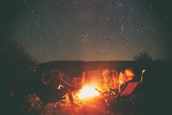 Two friends are sitting around a campfire and just relaxing