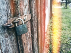 Old rusty padlock on wooden door. Abstract.
