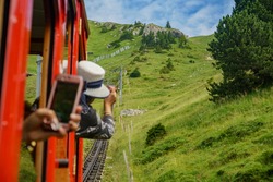 People taking the scenic view from the special train climbing up to the Mount Pilatus, Lucerne, Switzerland