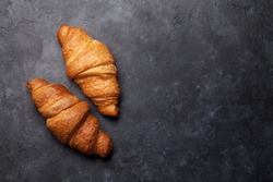 Fresh croissants on stone table. French breakfast. Top view flat lay with copy space for your text