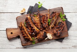 Barbecue beef ribs with bbq sauce sliced on a wooden board. Top view flat lay