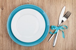 Fork with knife and blank plates. On wooden table background