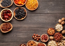 Various dried fruits and nuts on a dark wooden table. Top view flat lay with copy space