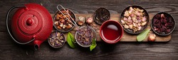 Various herbal dry tea, teapot and cup on wooden table. Top view flat lay