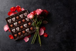 Rose flowers and heart shape chocolate. Valentines day greeting card with space for your greetings. Top view flat lay