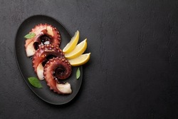 Grilled octopus with lemon. Top view flat lay with copy space