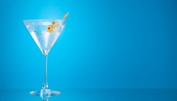 Martini cocktail on blue background with copy space