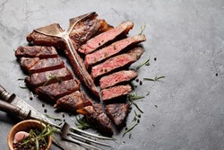 Grilled porterhouse beef steak. Sliced T-bone with herbs and spices. With copy space