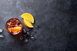 Negroni cocktail on dark stone table. Top view with space for your text