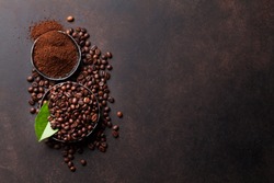 Coffee beans and ground powder on stone background. Top view with copy space for your text 