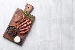 Grilled beef steak with spices on cutting board. Top view with copy space