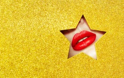 Beautiful Plump Bright Lips Of a Young Beautiful Woman with Red Lipstick Look Into the Pattern of Star made of Colored Paper. Yellow. Holiday Patterns. Golden Paper