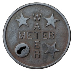 The cast iron cover plate for a water meter, isolated on a white background