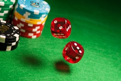 Rolling red dice on a casino table with chips