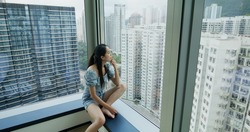 Woman sit beside the window and look outside the city view