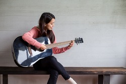 Woman play with guitar at home