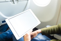 Woman holding digital tablet at airplane