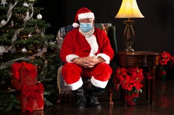 Santa Claus Sitting on a Chair and Wearing a Surgical Mask Looking at the Camera