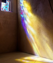 Stained Glass window with sun rays of colored light on wall and floor. St. Giles Cathedral. Edinburgh. Scotland. UK.