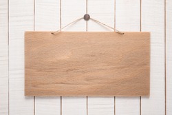 Signboard with rope on wooden background  