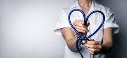 female doctor with heart shaped stethoscope. healthcare job love, cardiology or health insurance concept. copy space