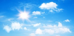 Sunny day background, blue sky with cumulus clouds and summer or spring sun as nature background.