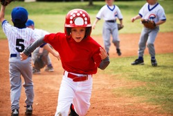 Youth baseball boy running bases.