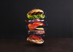Delicious, juicy burger layers over a dark background