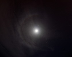 Circular halo round full Moon on black sky background
