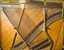 Keyboards. Different details and parts of the ancient piano close up. Piano Strings are stretched on an iron frame