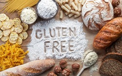Gluten free food. Various pasta, bread, snacks and flour on wooden background from top view